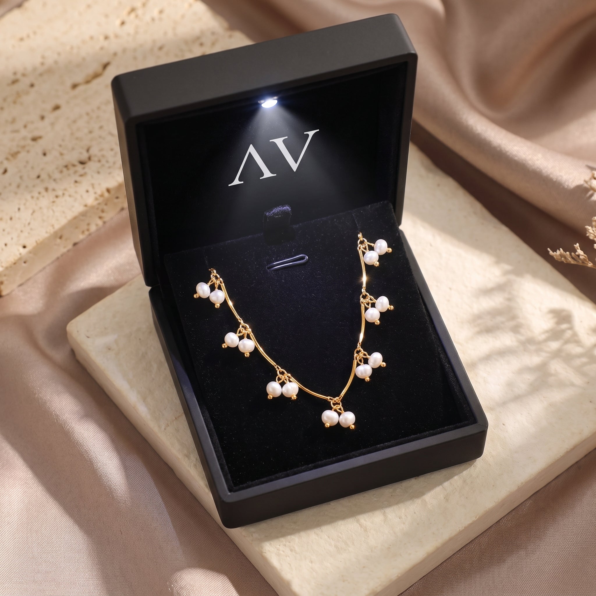 Aurendra gold and pearl necklace inside a black premium gift box with an integrated LED light.
