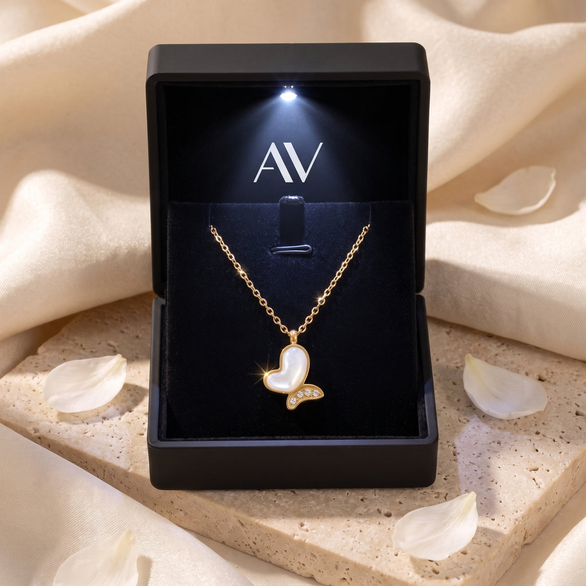 Gold mother of pearl butterfly necklace displayed in a black LED-lit jewelry gift box.