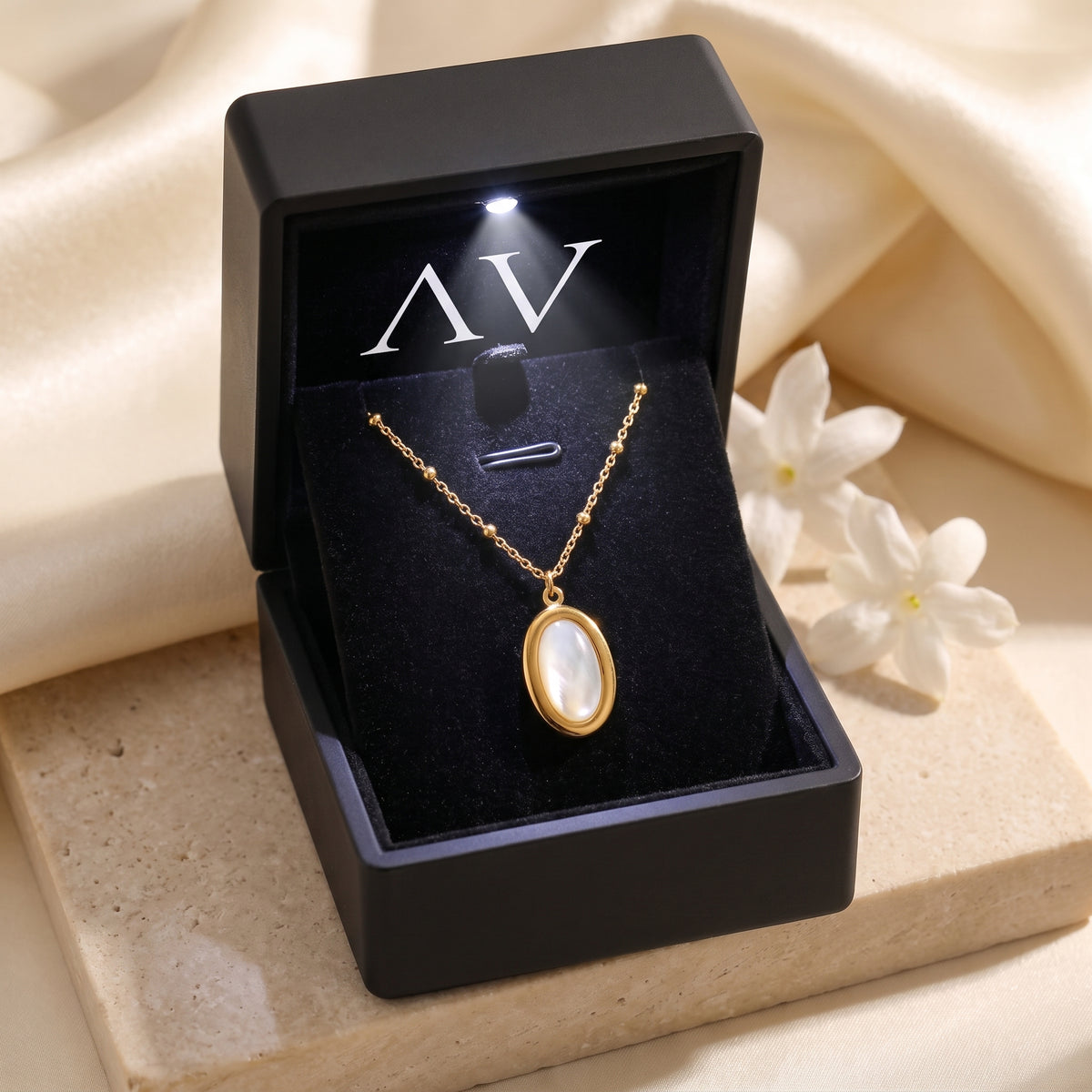 Gold mother of pearl necklace in a black LED jewelry box.