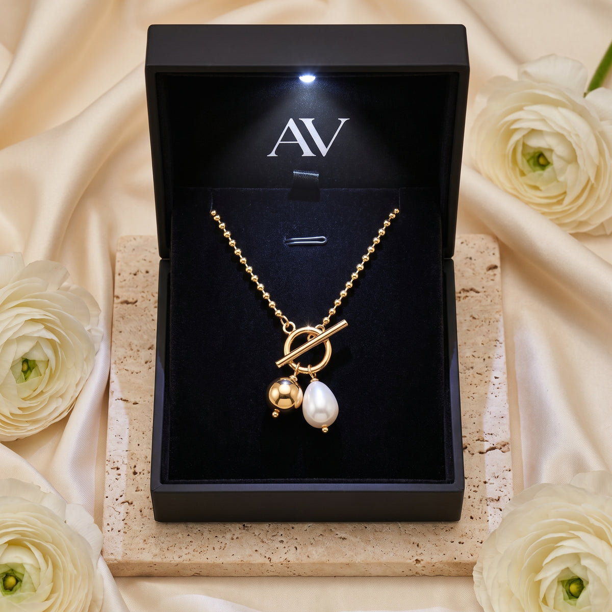 Gold pearl toggle necklace inside a premium black branded jewelry gift box.