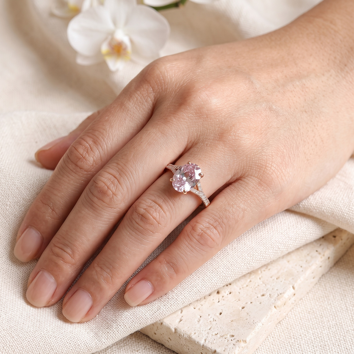 The Belina oval pink moissanite ring in rose gold worn on a model's hand.
