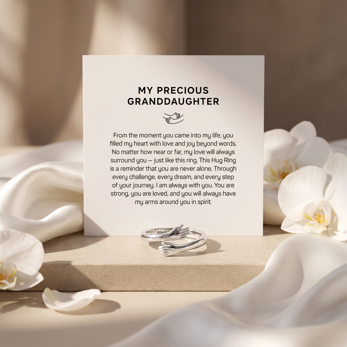 Silver hugging-arms ring beside the included My Precious Granddaughter message card