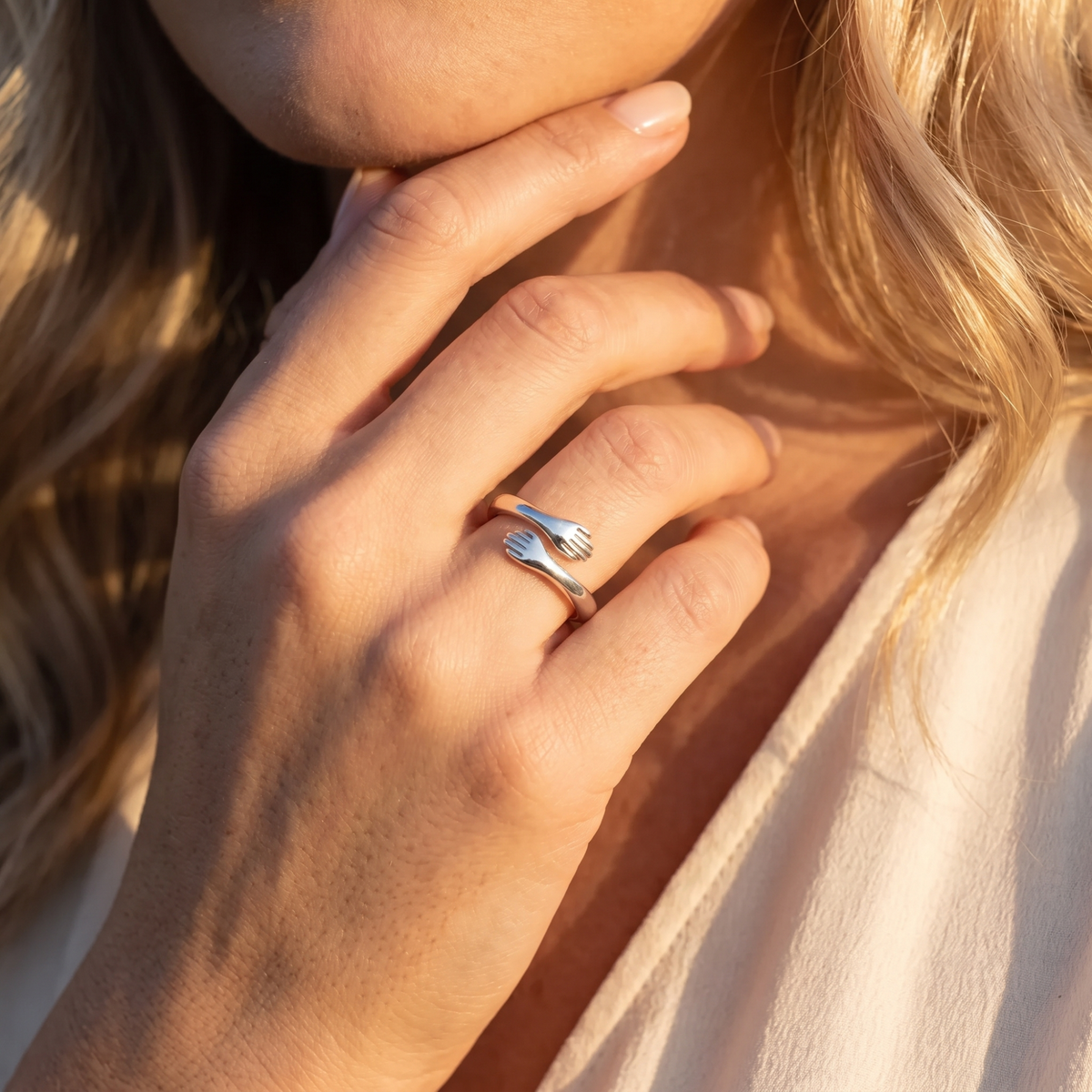 Silver hug ring worn on a hand