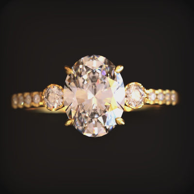 Video of The Luna solid gold ring with an oval moissanite stone and simulated diamond eternity band.