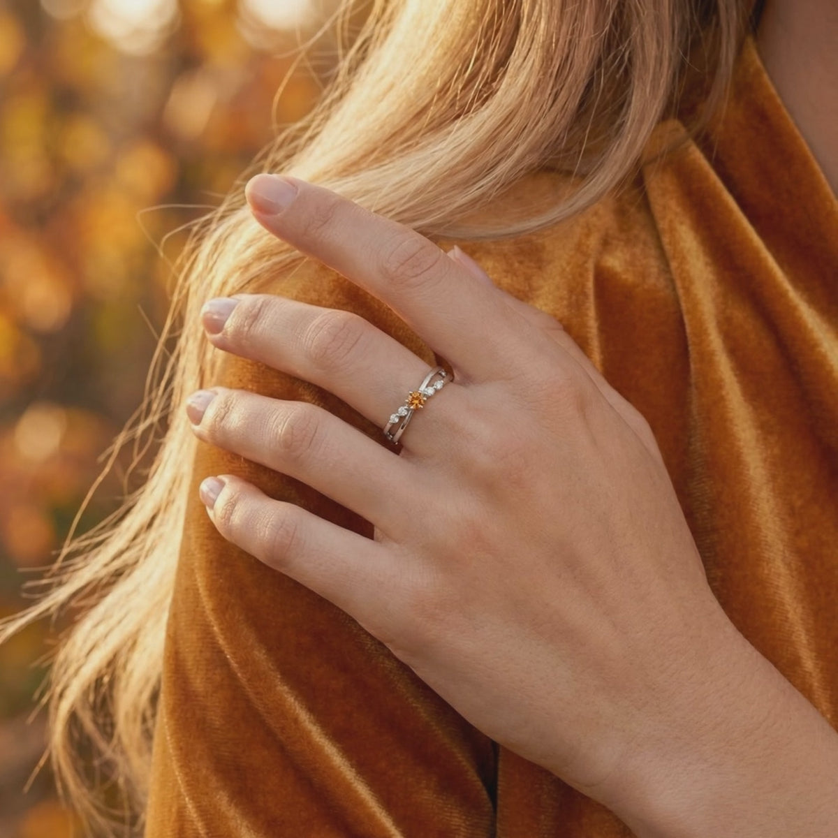 Solid white gold crossover ring featuring a simulated topaz.