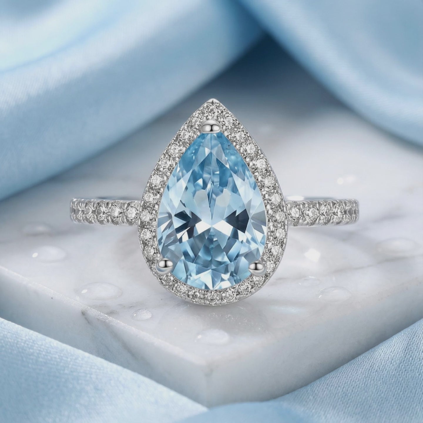 Pear halo simulated aquamarine ring in solid gold.
