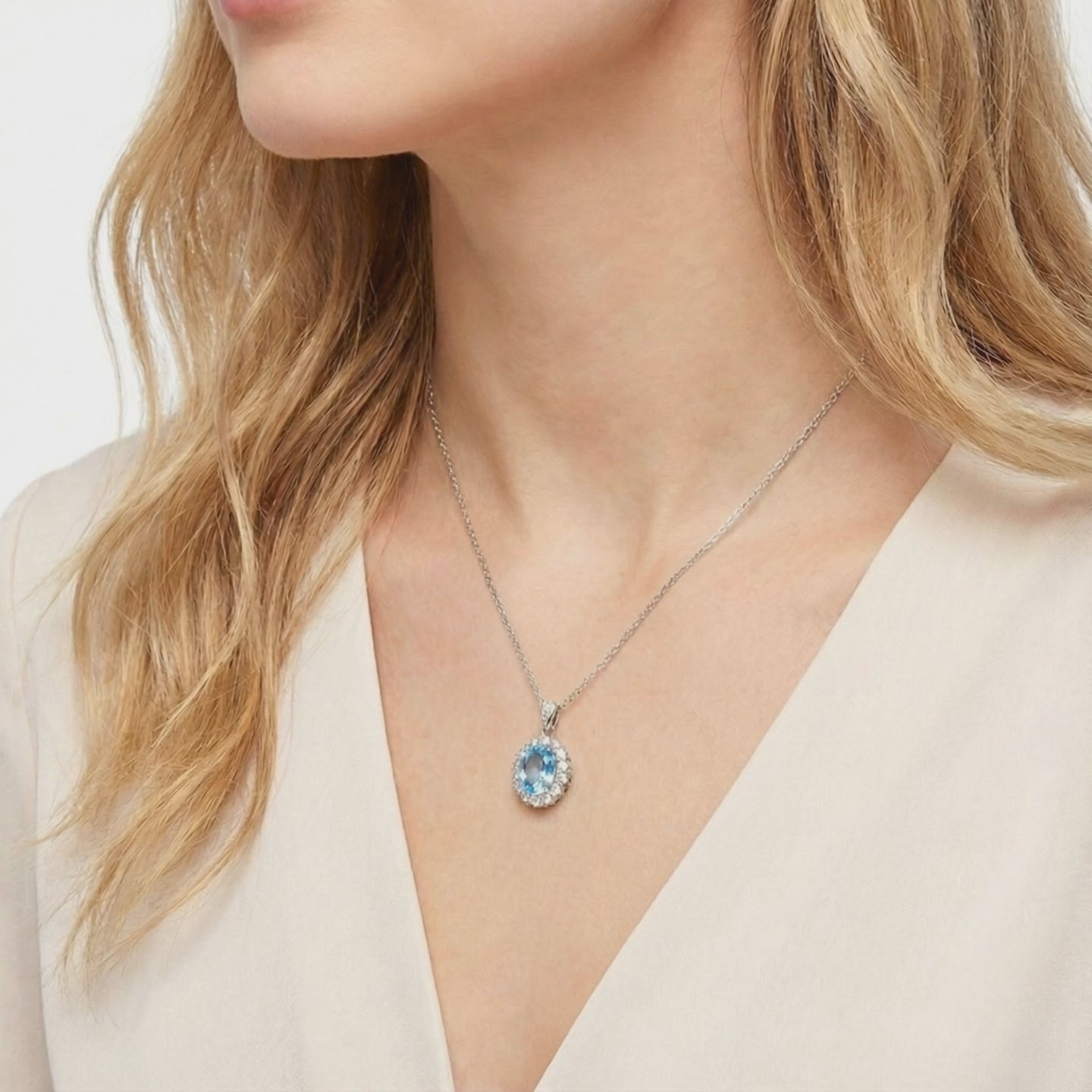 Simulated aquamarine halo pendant necklace in solid gold.