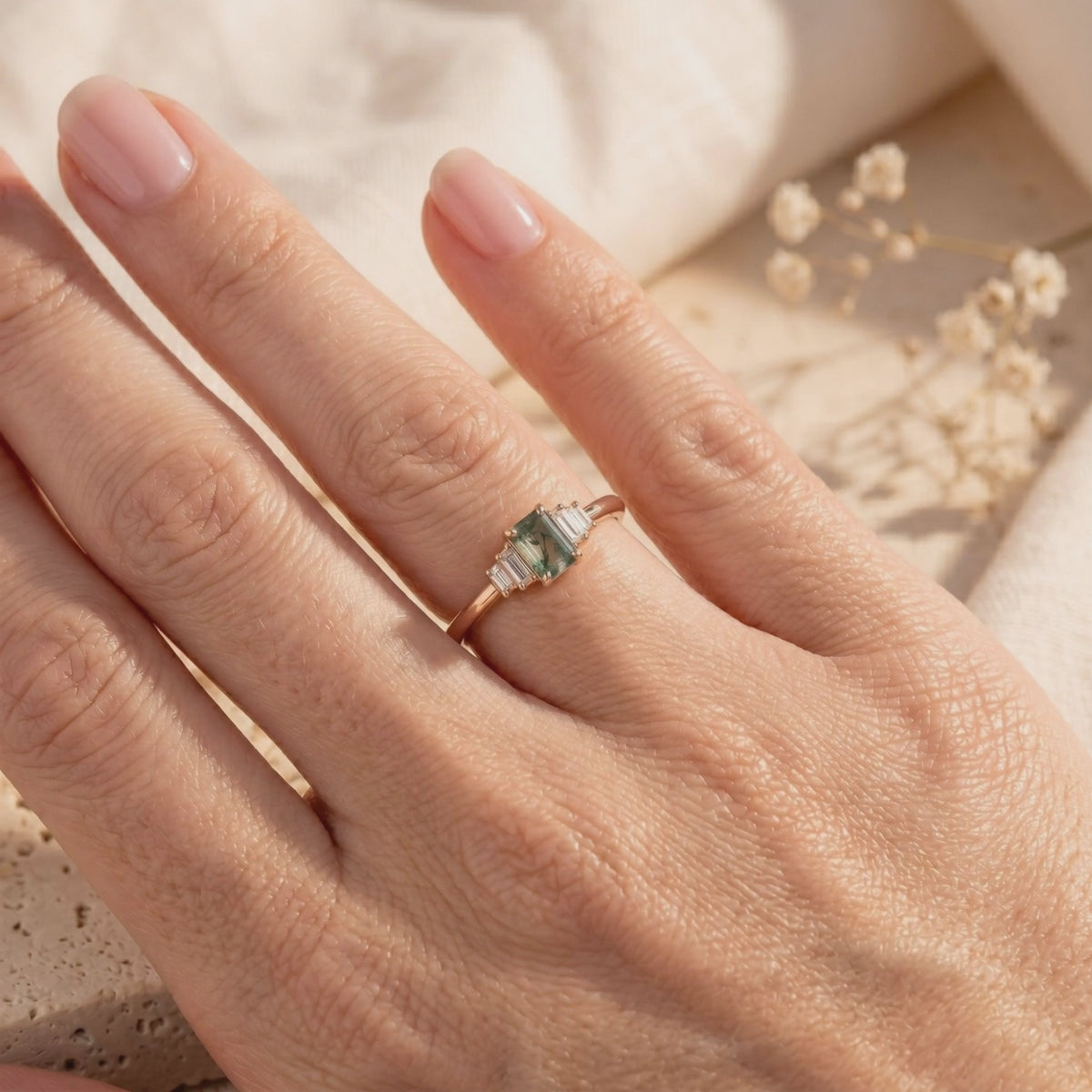 Solid gold ring with emerald-cut moss agate and baguette accents.