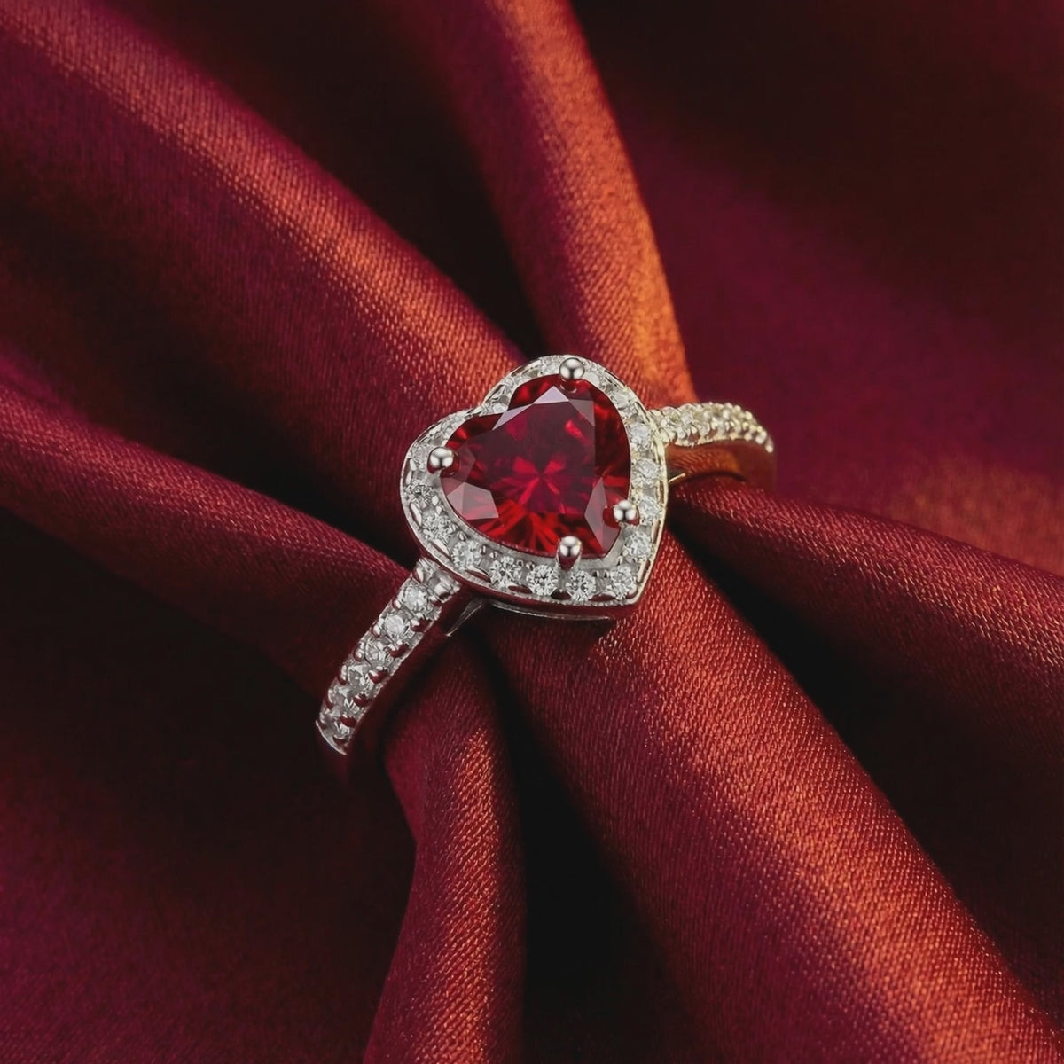 A solid gold ring with a heart-shaped simulated ruby.