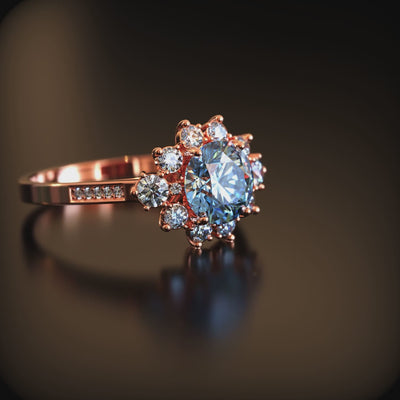 A blue moissanite halo ring in solid gold.