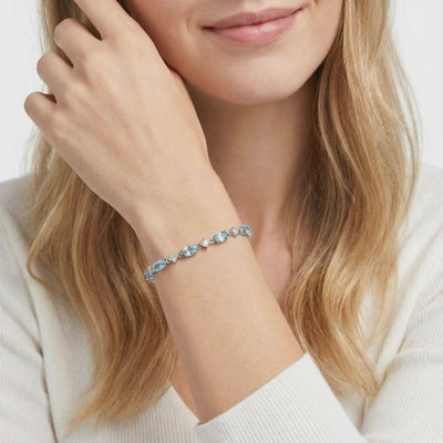 Coralia station bracelet with simulated aquamarine stones in solid gold.