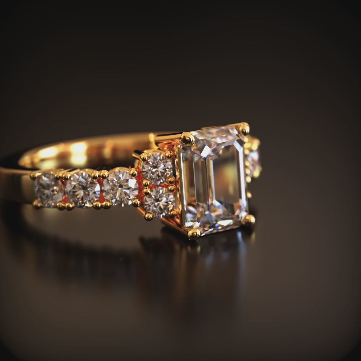 A solid gold ring with an emerald cut moissanite