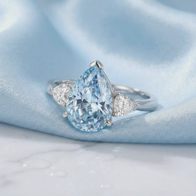 Detailed view of the pear-cut simulated aquamarine ring in solid white gold.