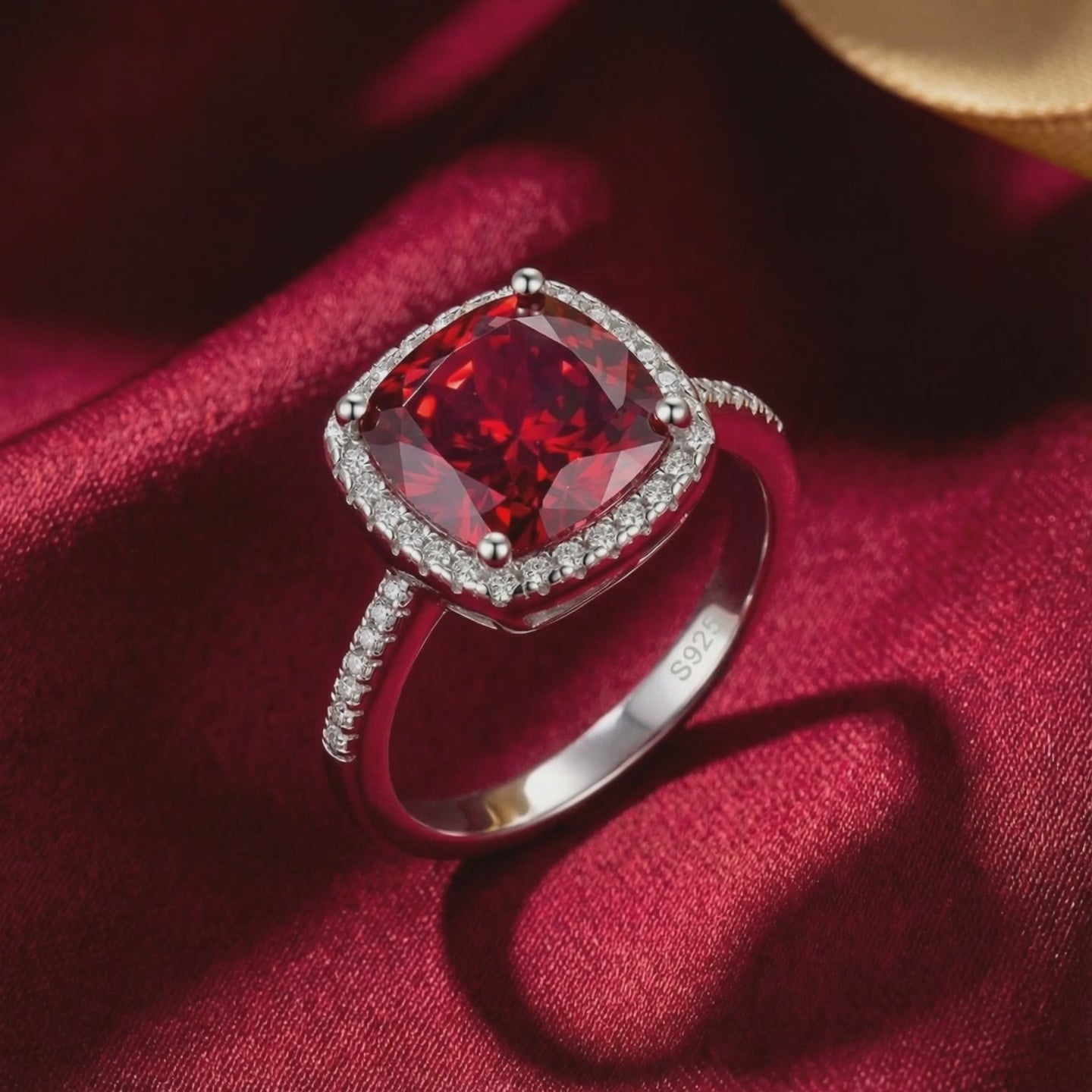 Detailed view of the cushion-cut simulated ruby halo ring in solid white gold.