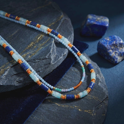 Layered solid gold necklace with natural lapis lazuli beads.
