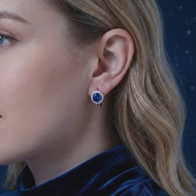 Blue moissanite halo stud earrings in solid gold.