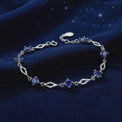 Solid gold station bracelet with simulated sapphires.