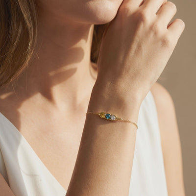 The Adelaide solid gold pea pod bracelet featuring simulated birthstones.