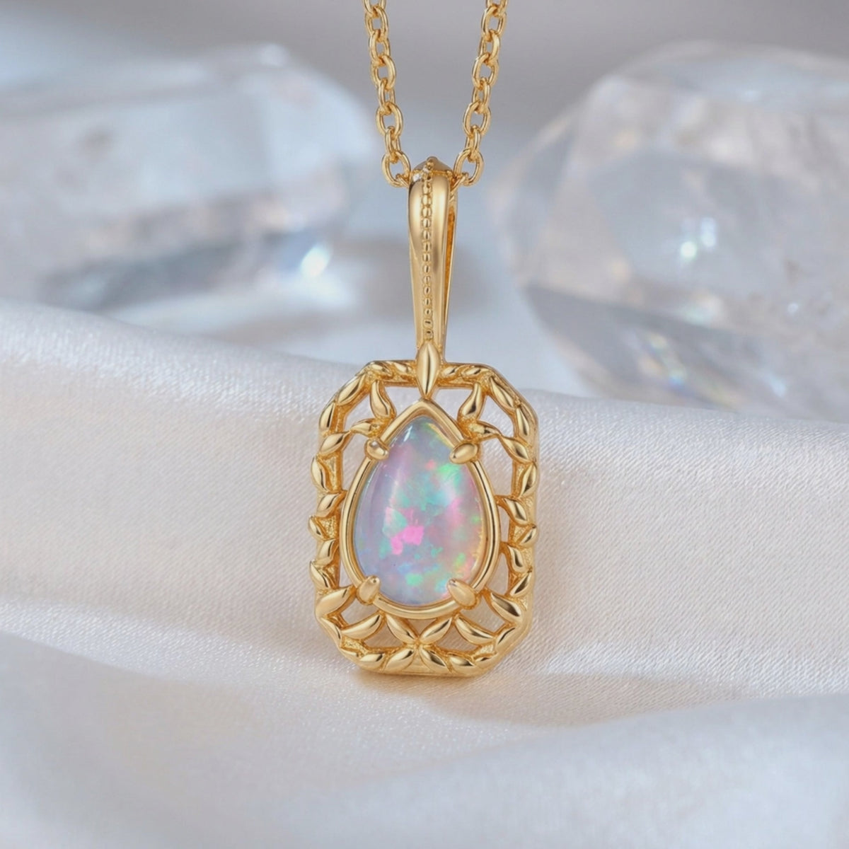 Close-up of a solid gold necklace with a pear-shaped iridescent opal pendant.