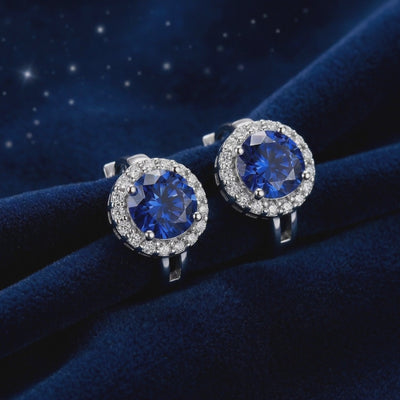 Blue moissanite halo stud earrings in solid gold.