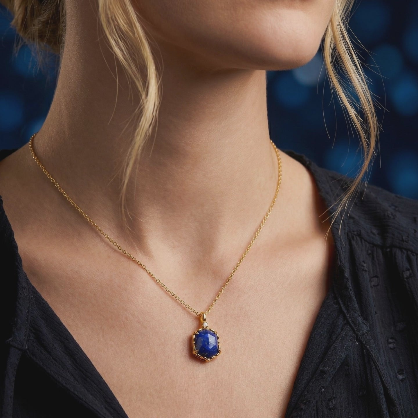 A solid gold necklace with a lapis lazuli pendant.