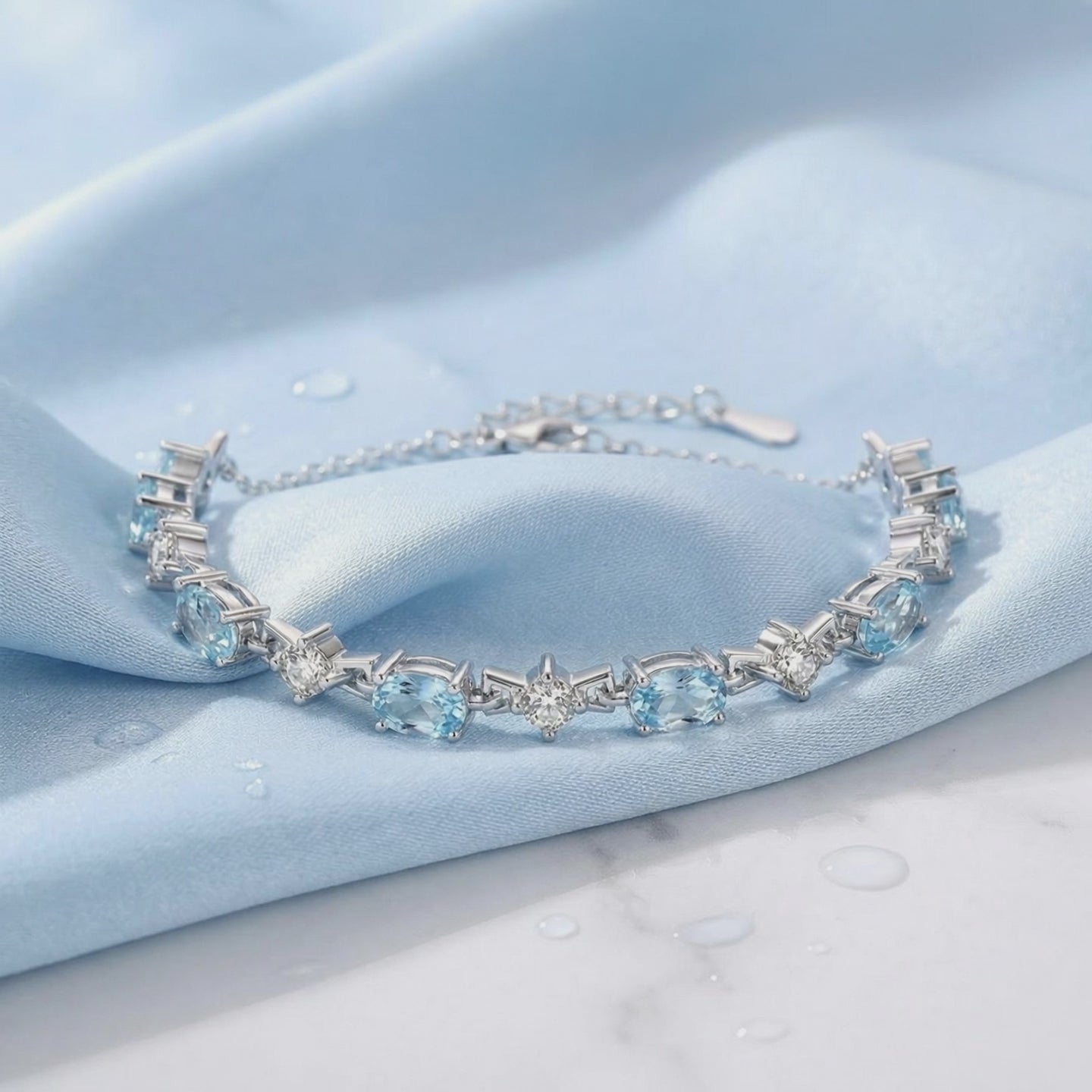 Coralia station bracelet with simulated aquamarine stones in solid gold.