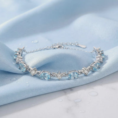 Coralia station bracelet with simulated aquamarine stones in solid gold.