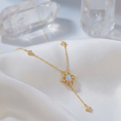 Solid gold necklace with an oval white opal pendant.