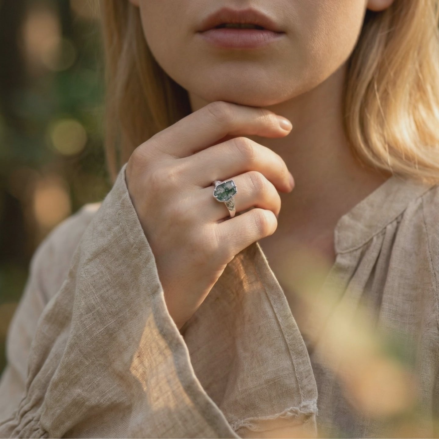A solid white gold moss agate ring with a leaf design.