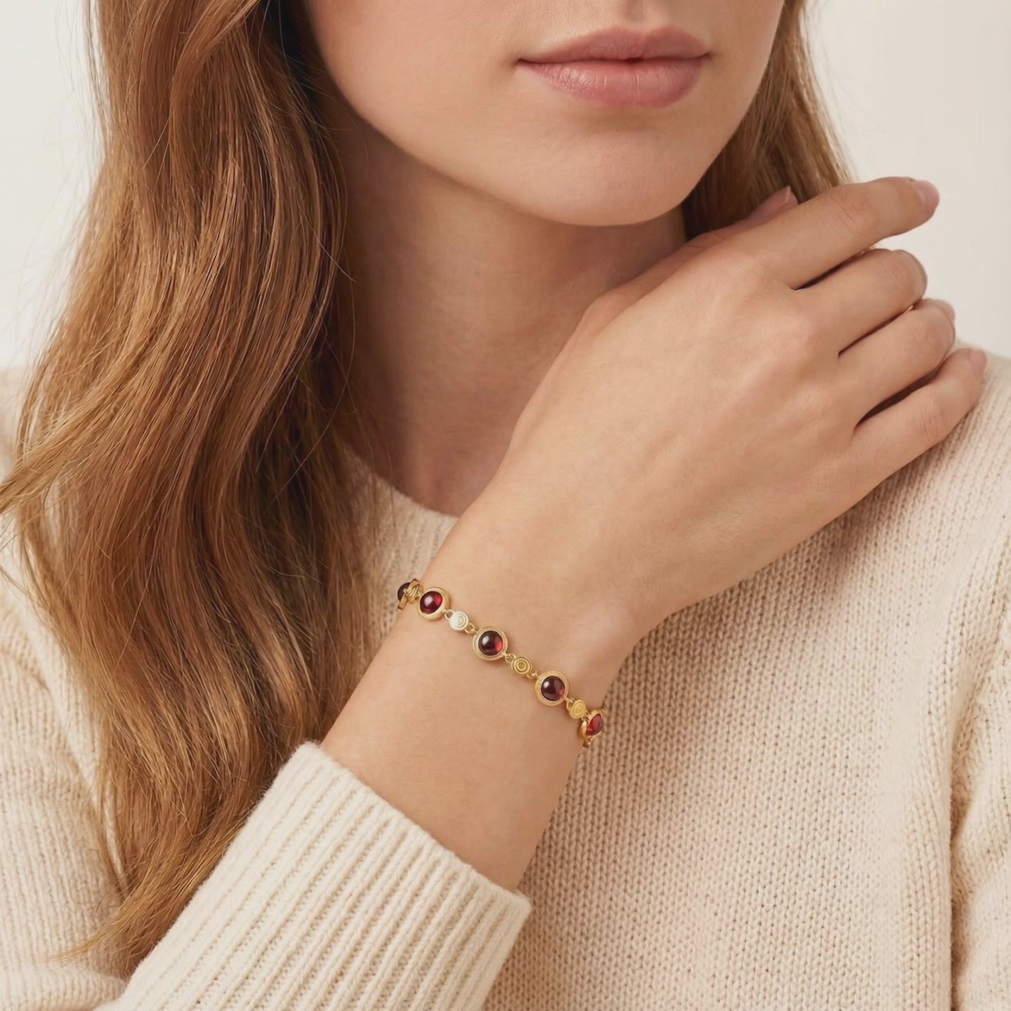 The Calyssa solid gold station bracelet featuring precision-cut simulated garnets.