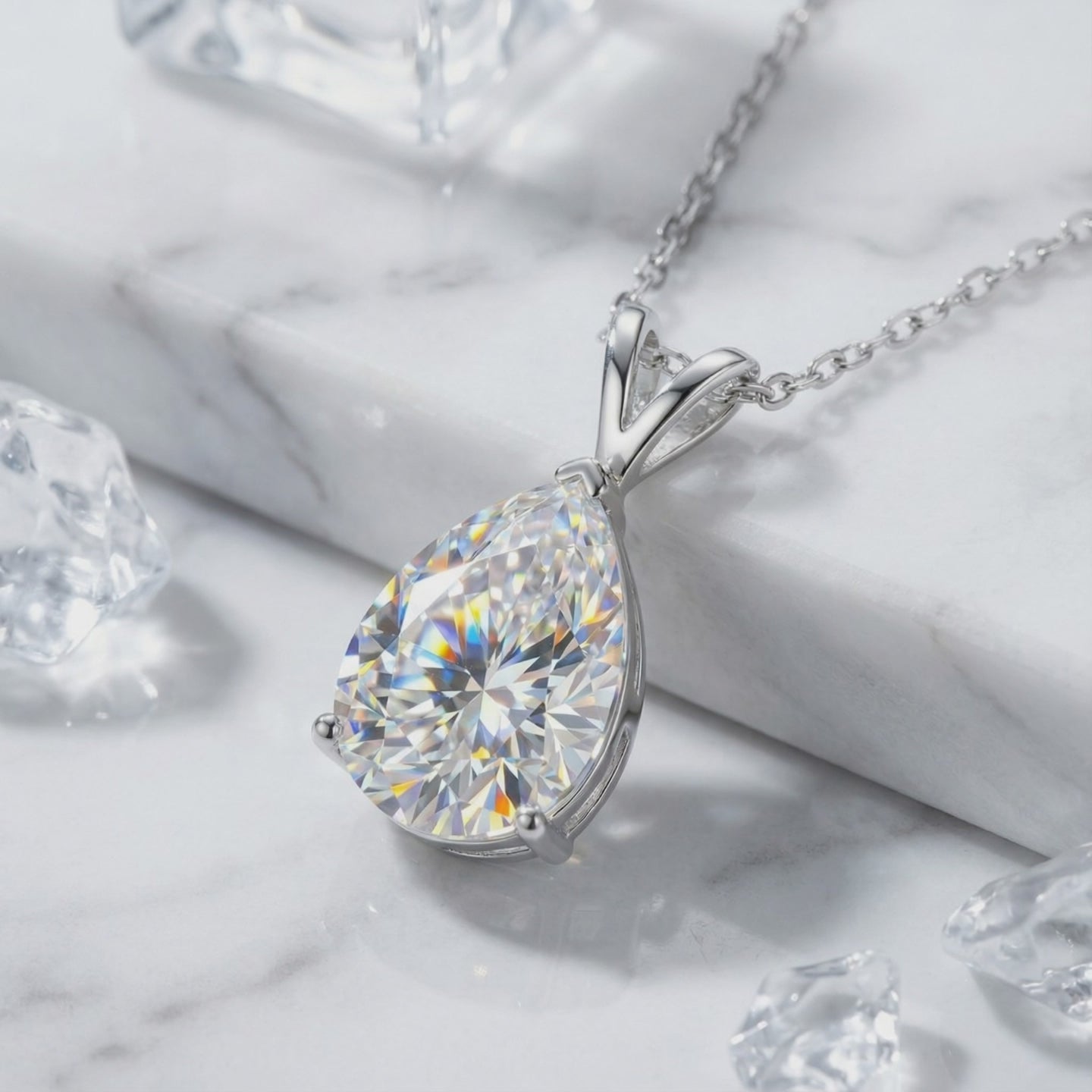 A necklace with a pear-cut moissanite pendant in solid gold.