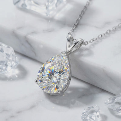 A necklace with a pear-cut moissanite pendant in solid gold.