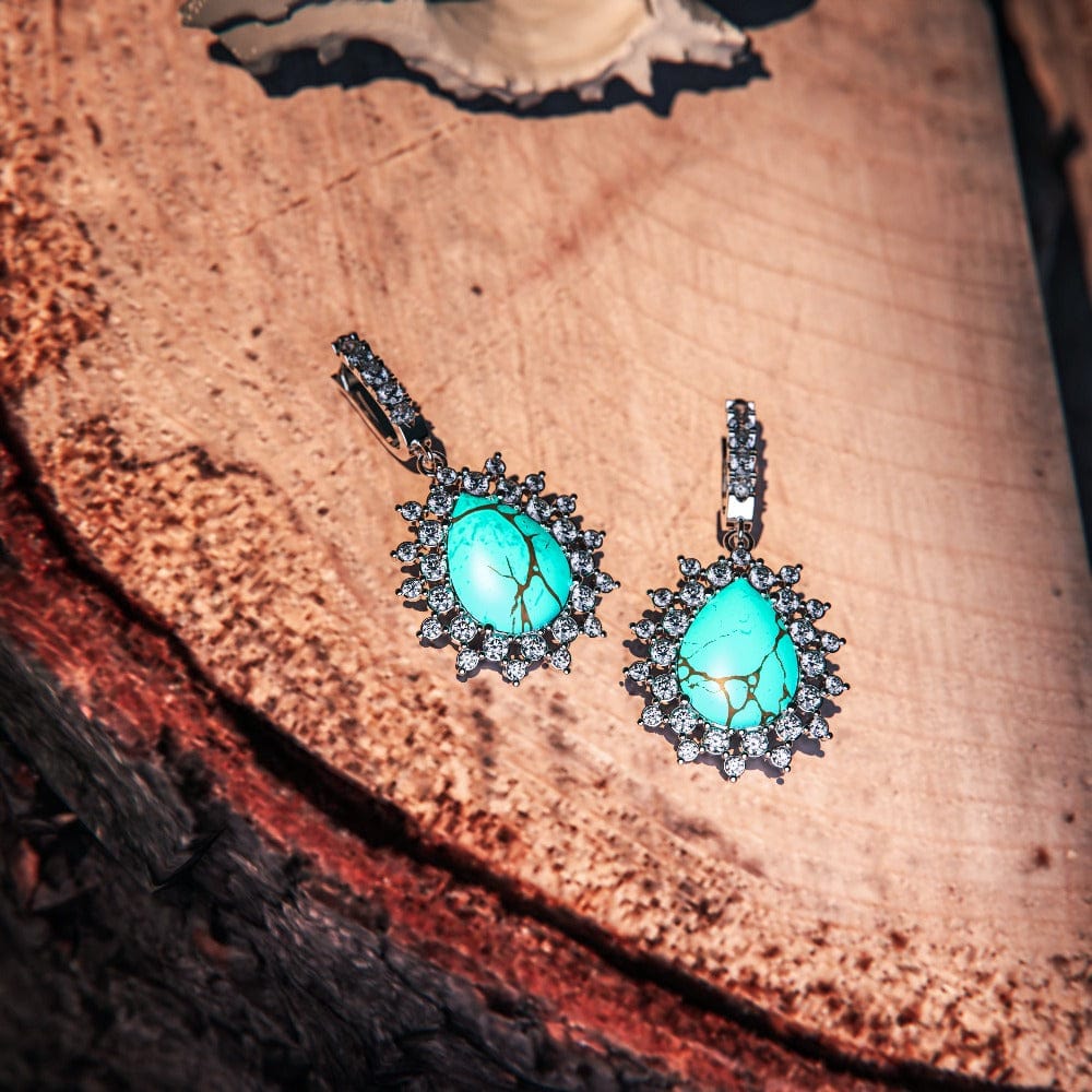 Blue Lagoon Turquoise Earrings featuring turquoise stones set in S925 sterling silver zoomed out view laying on a flat surface