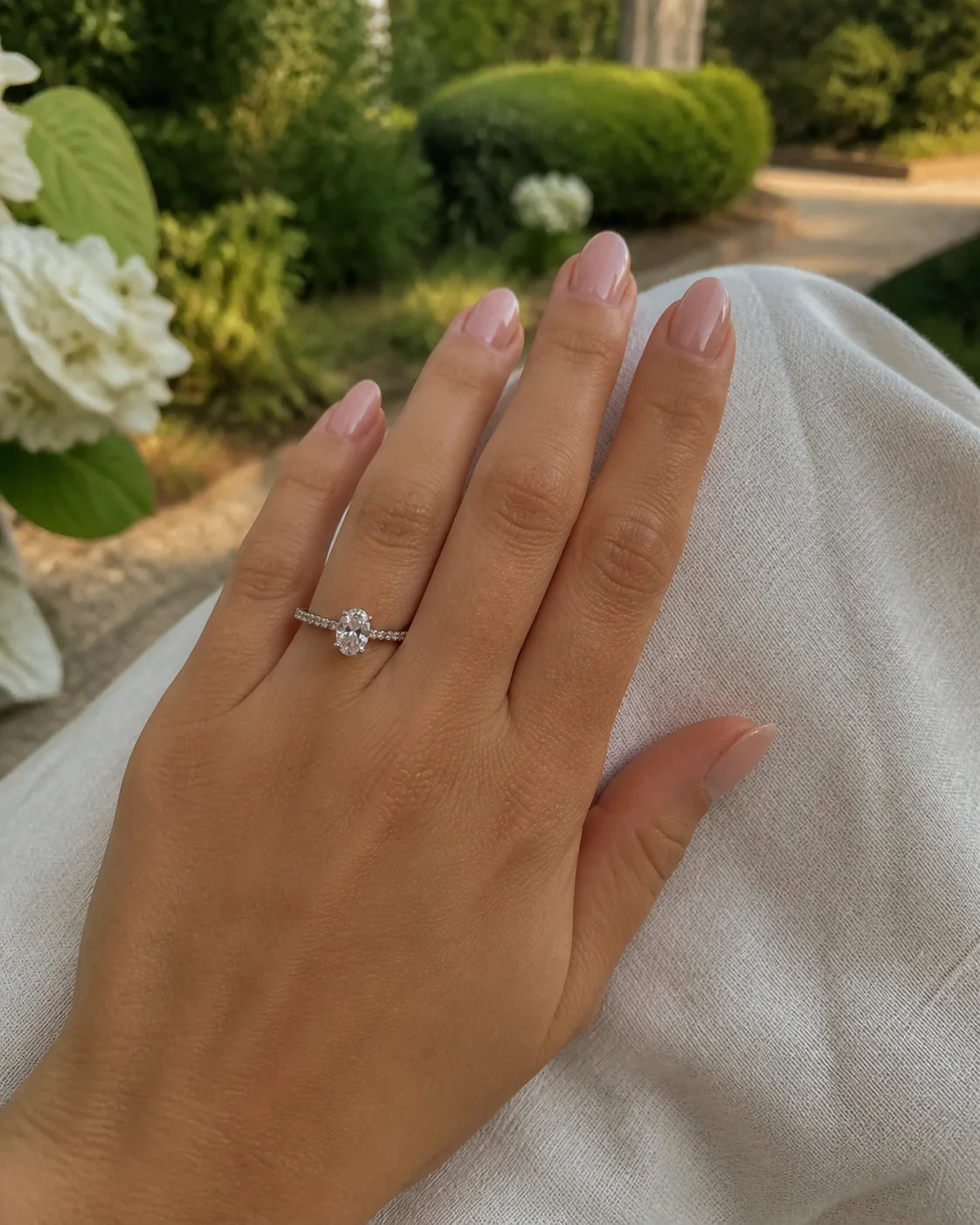 Oval fine-jewelry ring photographed in a sunlit garden