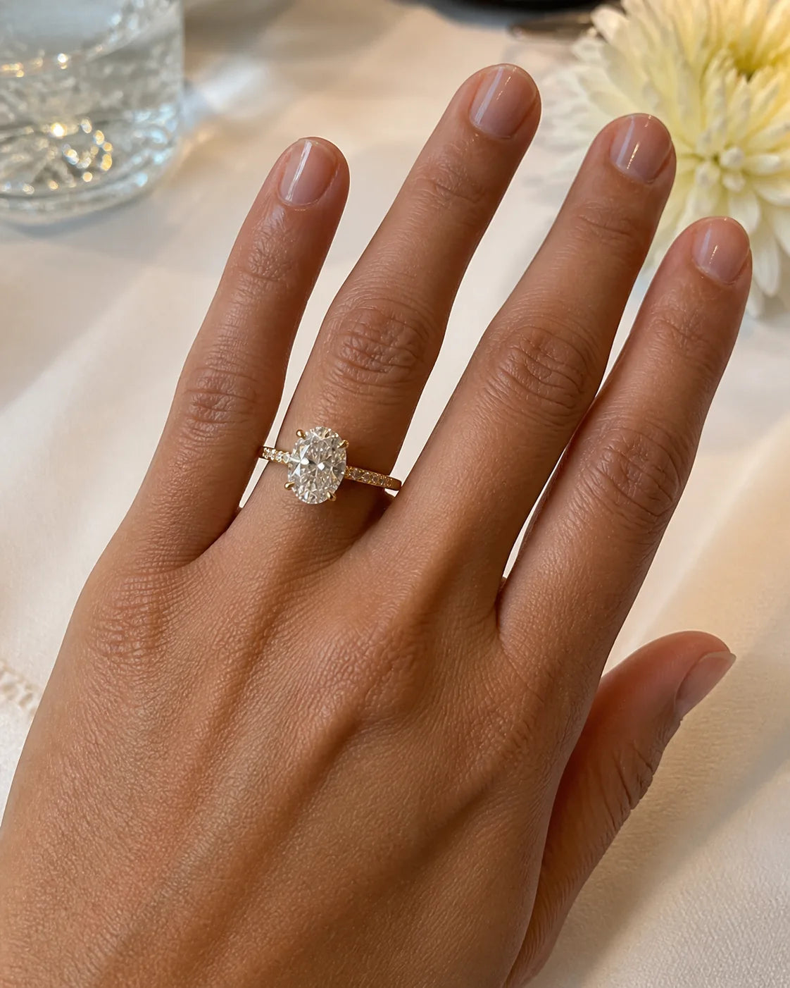 Oval engagement ring photographed at a celebratory table